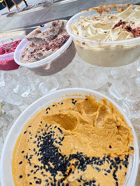 A close-up of Obour Berbere hummus topped with black sesame, on ice