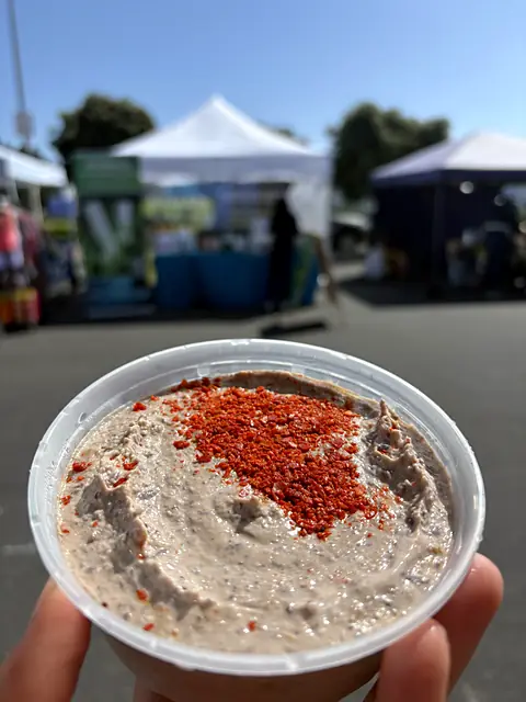 A tub of Obour Black Bean hummus topped with chile flakes