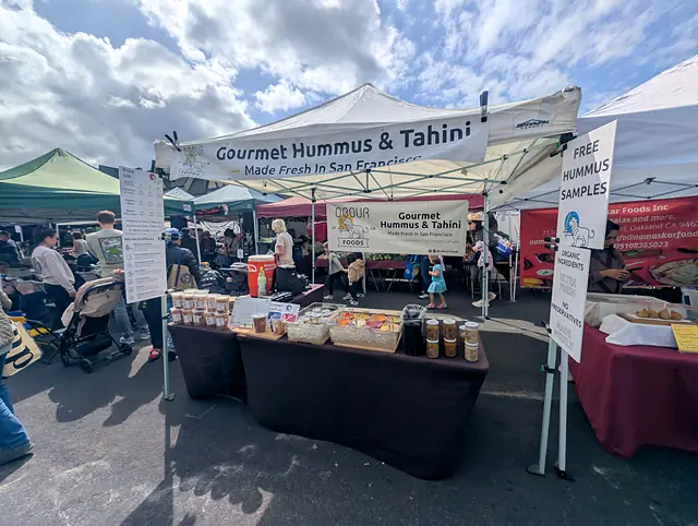 The Obour tent on a busy market morning, with shoppers walking by