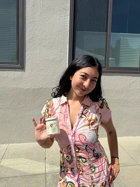 A shopper in a floral outfit holding a jar of Obour hummus