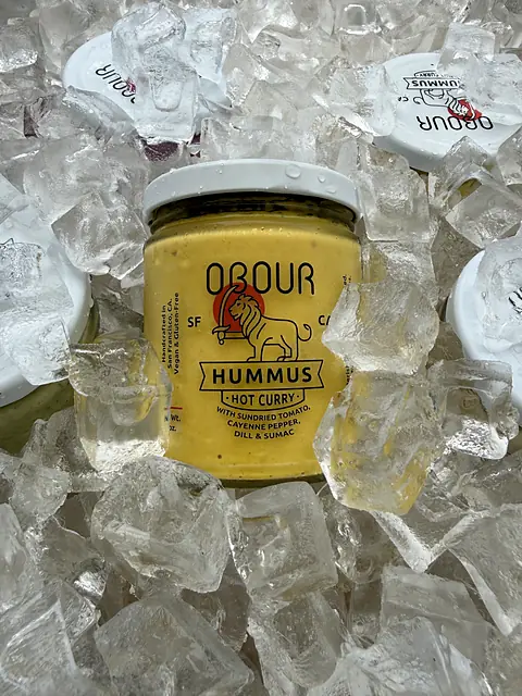 A jar of Obour Hot Curry hummus on ice