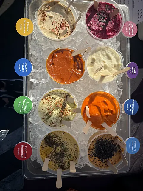 A labeled tray of Obour hummus and toum samples, including Awaze toum
