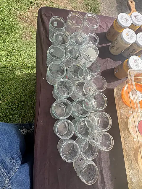 Rows of empty glass jars lined up on a market table