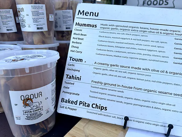 The Obour menu board next to tubs of pita chips