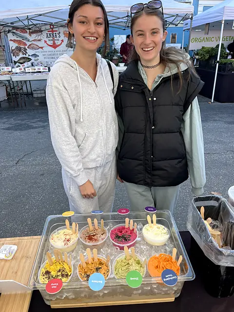 Two friends smiling behind the Obour sample tray
