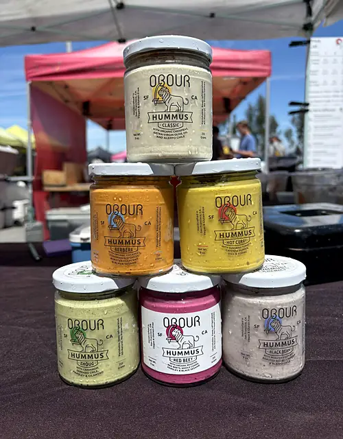 A pyramid of Obour hummus jars: Classic, Berbere, Hot Curry, Zhoug, Red Beet and Black Bean