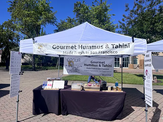The Obour tent on a sunny brick plaza