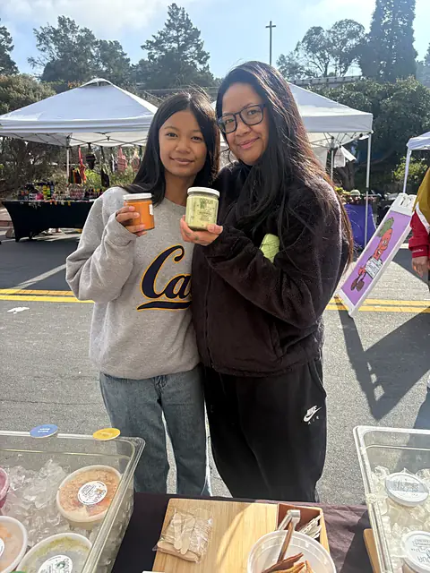 Two friends holding up jars of Obour hummus