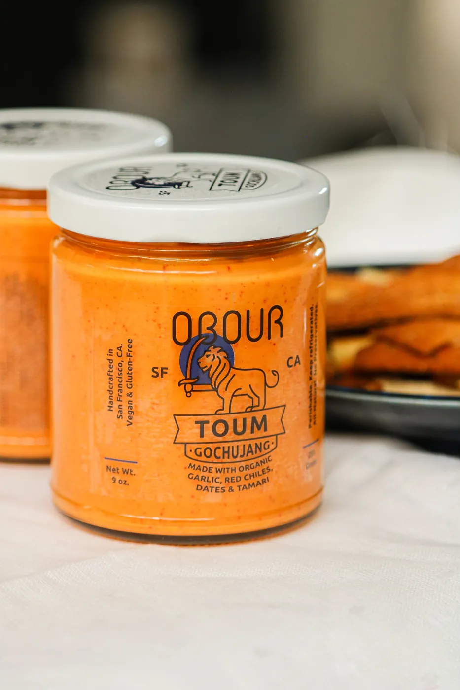 A jar of Obour Gochujang toum on a white table