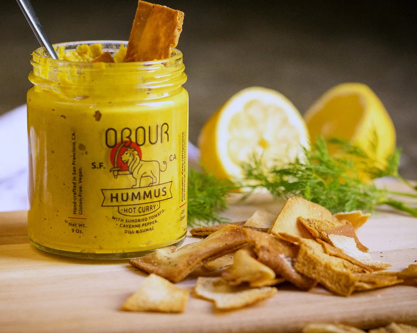 Hot Curry hummus with a pita chip, lemons and dill