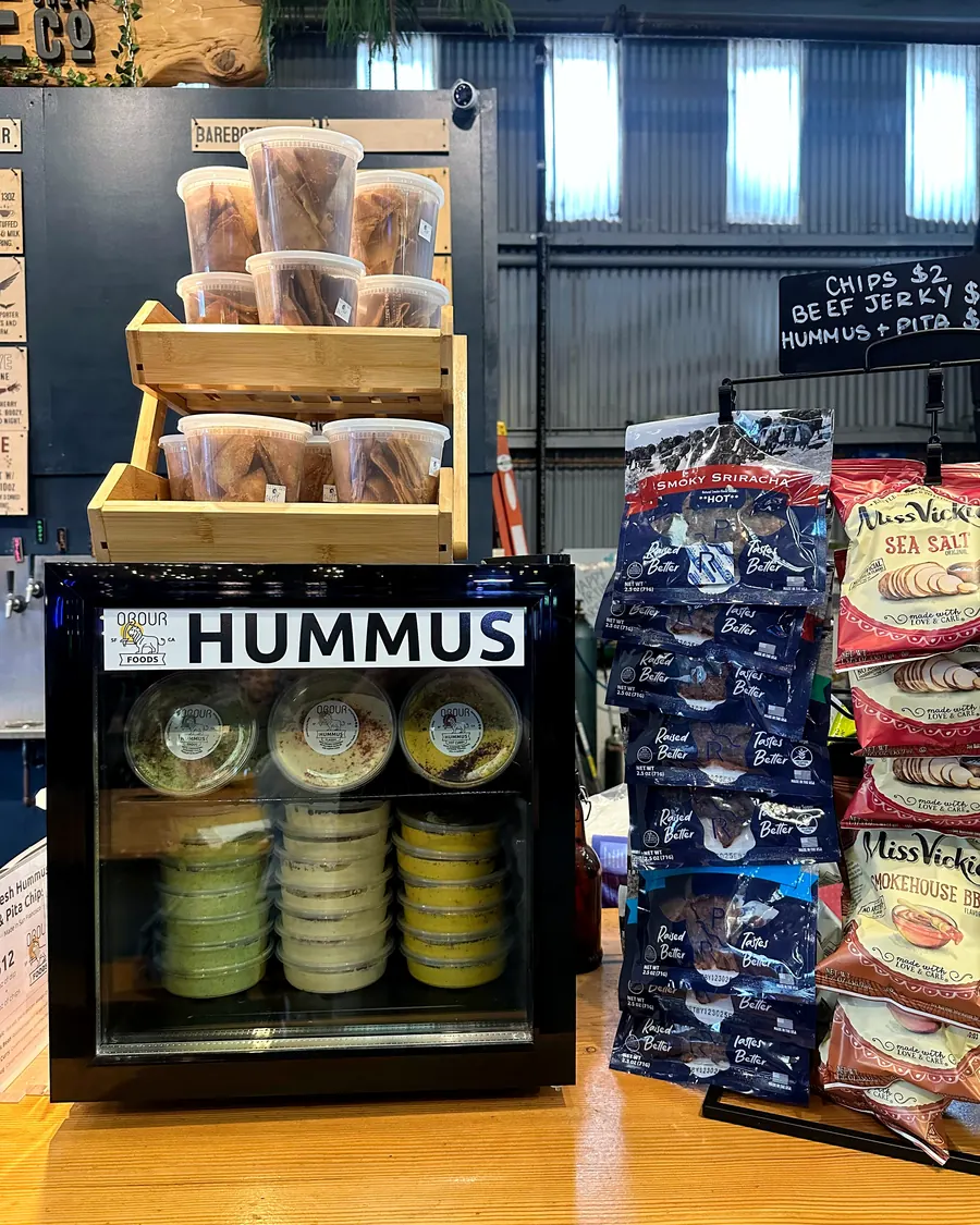 A branded Obour Hummus Fridge with a crate of pita chips